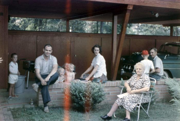 Family sitting under a carport