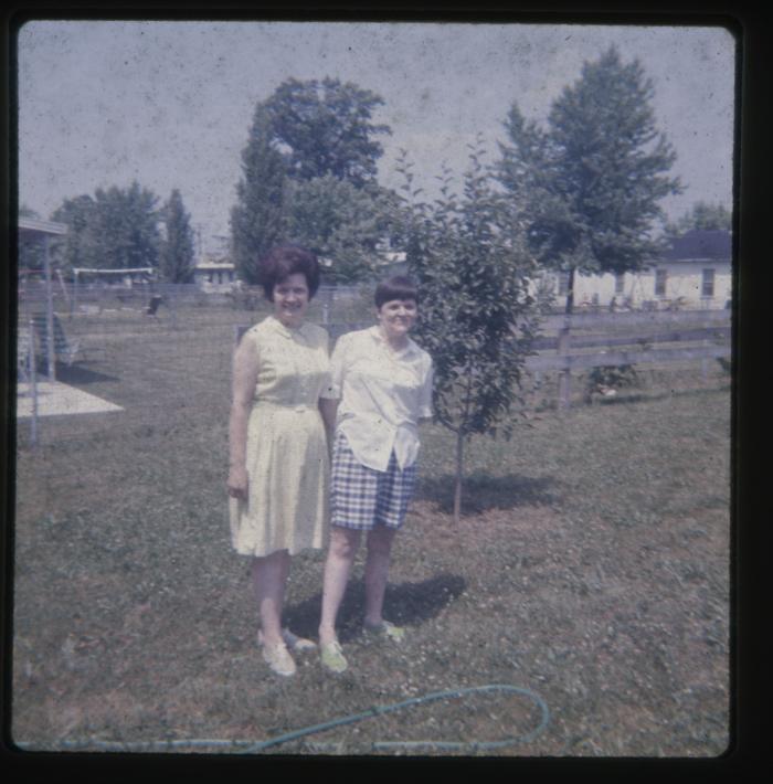 Two women standing in a yard