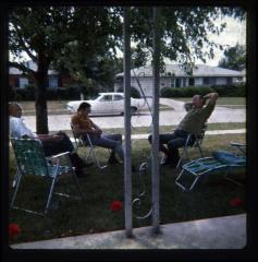 Men sitting in lawn chairs on front yard