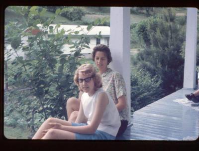Woman and young girl sitting on a porch