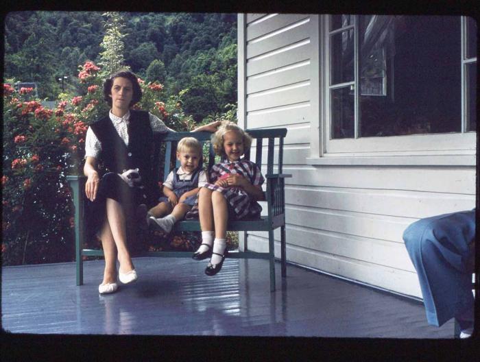 Woman and two children on porch bench