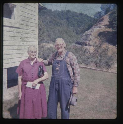 Man and woman standing beside a white house