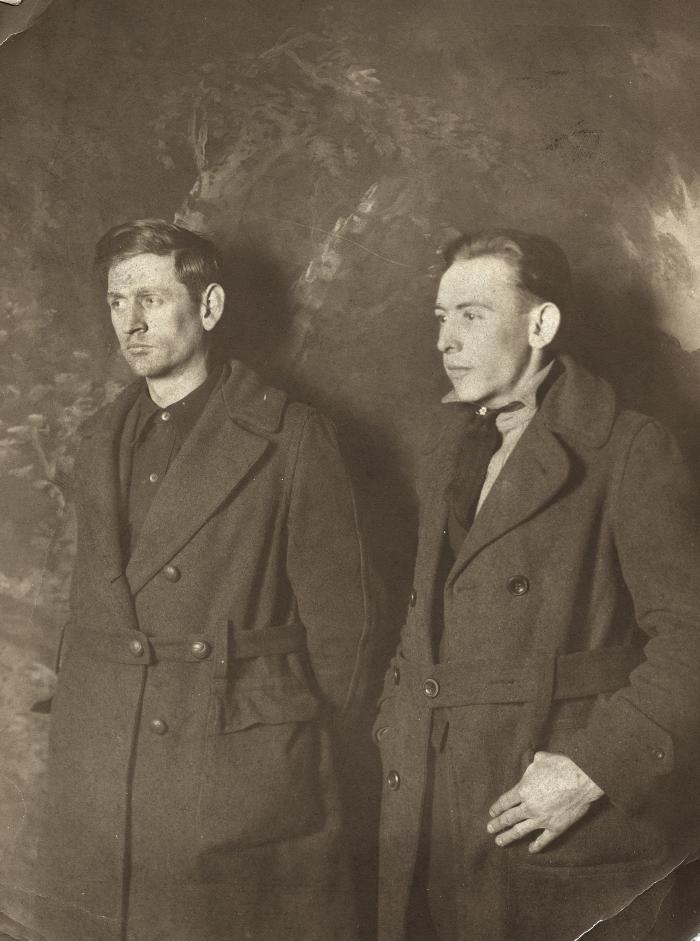 Two men in coats posing for a photo
