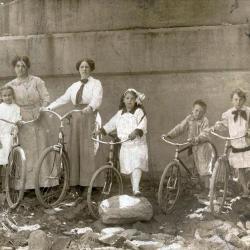Group of children and adults standing next to bicycles
