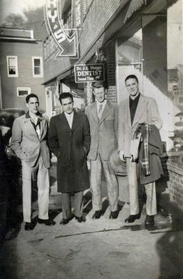 Four men standing in front a building