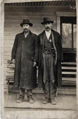 Two men standing on hotel porch