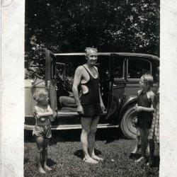 Man and children in front of car