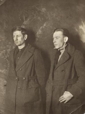 Two men in coats posing for a photo