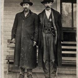 Two men standing on hotel porch