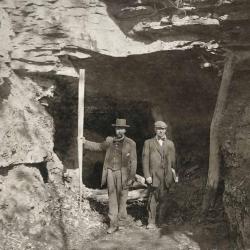 Two men standing beside a coal mine