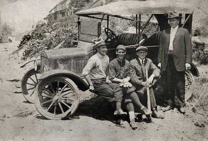 Four men next to a car