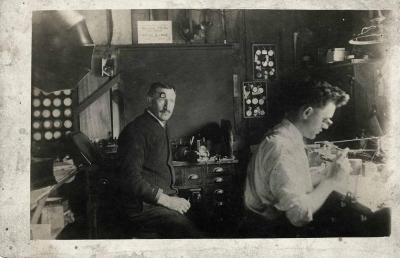 Two men sitting in a watch repair shop