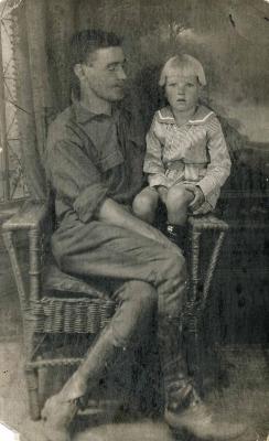 Man sharing a chair with his young son