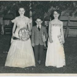 Two  young girls and a young boy holding musical instruments