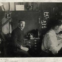 Two men sitting in a watch repair shop