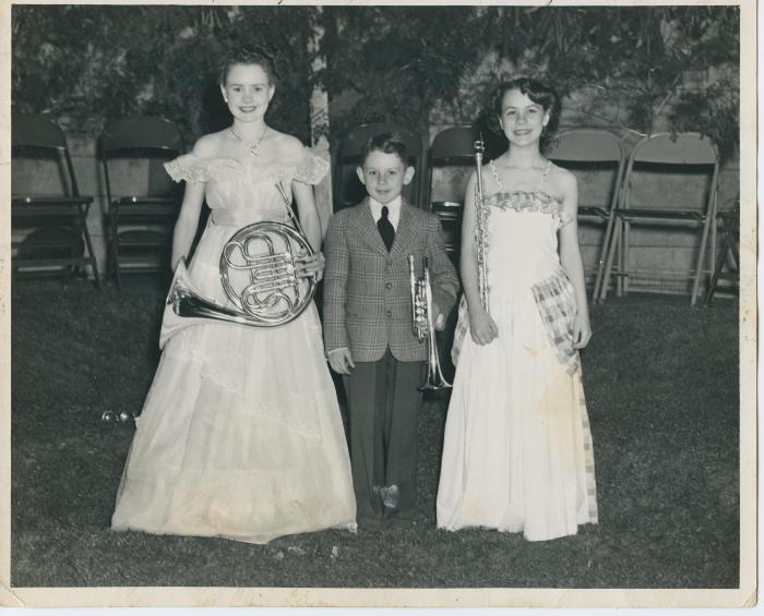 Two  young girls and a young boy holding musical instruments