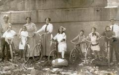 Group of children and adults standing next to bicycles