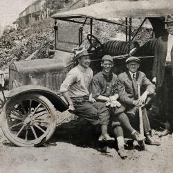 Four men next to a car