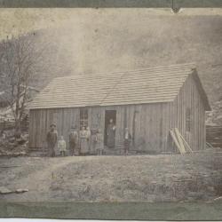 Group of people in front of wooden house