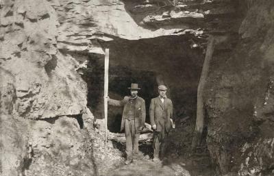 Two men standing beside a coal mine