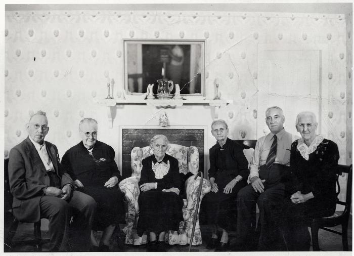 Group of people sitting in front of fireplace