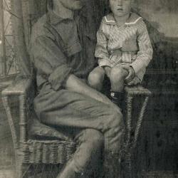 Man sharing a chair with his young son