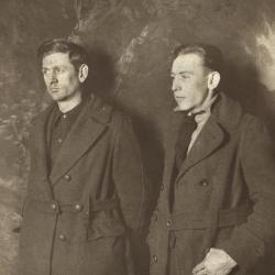 Two men in coats posing for a photo
