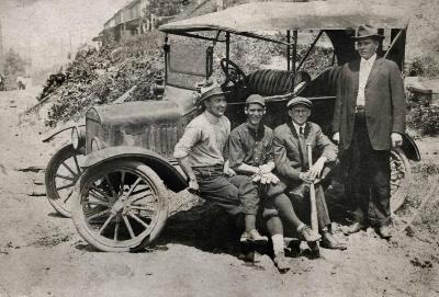 Four men next to a car