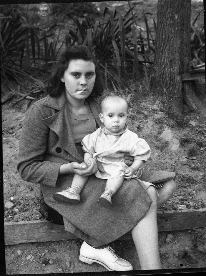 Woman posing for a photo with a child outdoors