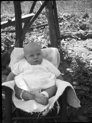 Baby posed for a photo in a chair outdoors