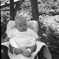 Baby posed for a photo in a chair outdoors