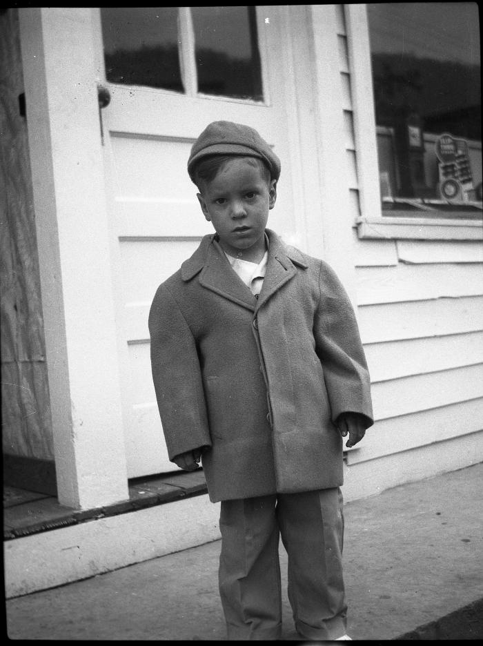 Boy posing in front of white house
