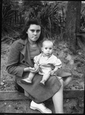Woman sitting outdoors and holding a child