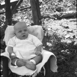 Baby posed for a photo in a chair outdoors