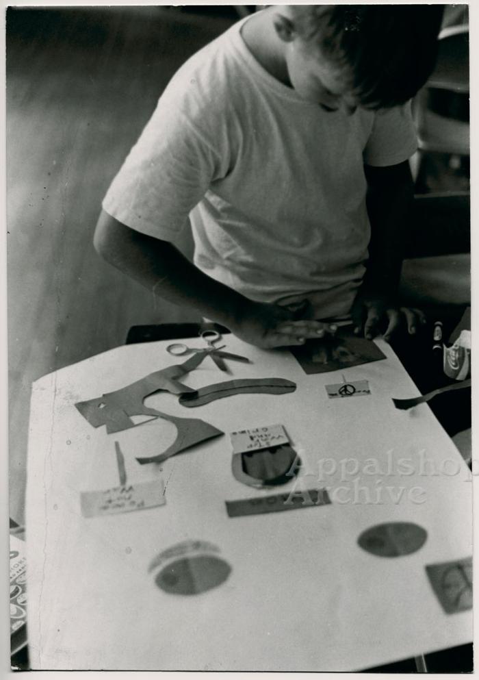 Production still of child making a collage - The Struggle of Coon Branch Mountain