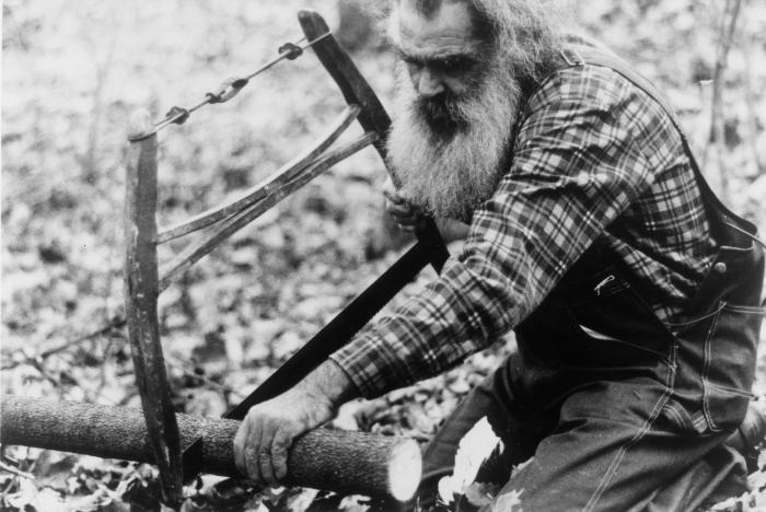 Chester Cornett sawing a tree - Hand Carved production still