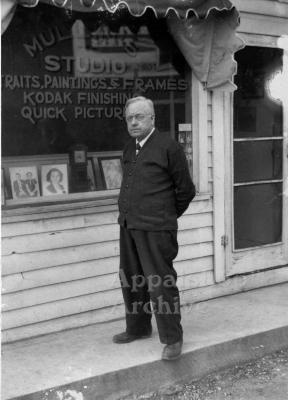 Portrait of William R. Mullins standing in front of his studio