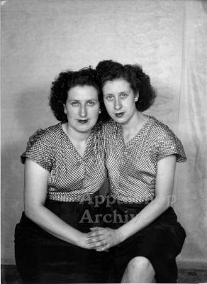 Studio portrait of 2 women in matching outfits