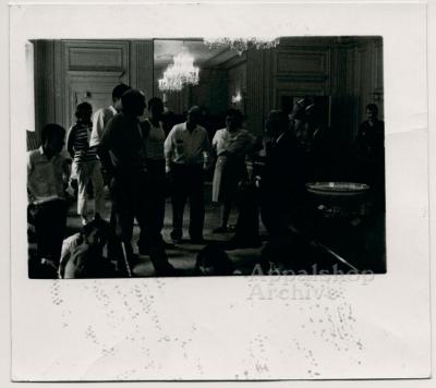 A group of people standing in a room with chandeliers, talking - The Struggle of Coon Branch Mountain