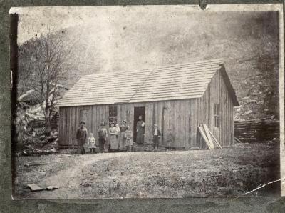Group of people in front of wooden house