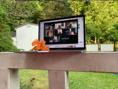 Monitor on porch railing displays virtual meeting