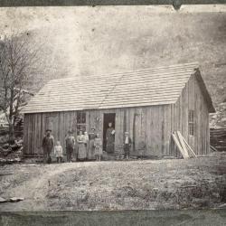 Group of people in front of wooden house