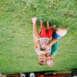 Girl hugging a young boy on lawn
