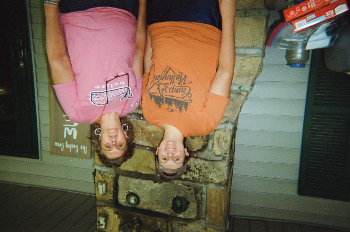 Two women on porch, "The Owsley Crew" sign in background