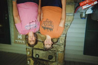 Two women on porch, "The Owsley Crew" sign in background