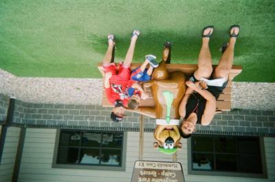 Woman and two boys on bench with Yogi Bear statue, Mammoth Cave State Park