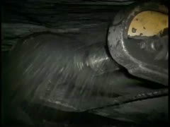 Footage inside coal mine with machine noise, discussion of fossils