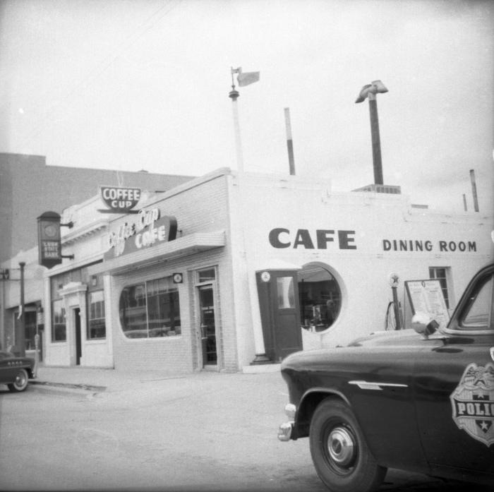 Exterior photograph of street corner with Coffee Cup Cafe and Lusk State Bank