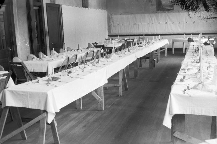 Long tables with place settings at event hall 