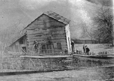 Family poses in front of notched-wood home